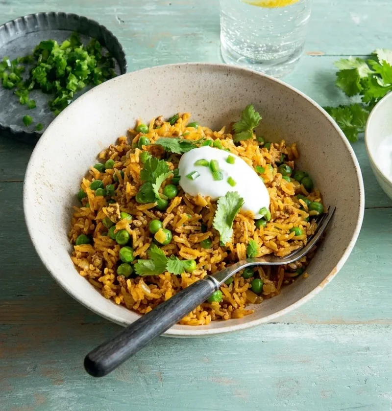 Hairy Bikers keema rice in a speckled bowl, golden basmati with lamb mince, green peas, yoghurt and coriander