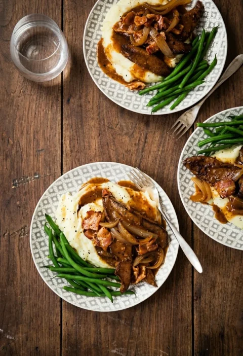 Hairy Bikers liver and bacon on patterned plates with onion gravy, mashed potato and green beans