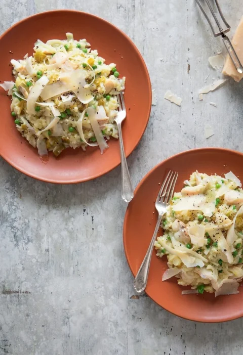 Hairy Bikers smoked haddock risotto on two terracotta plates with peas, leek and shaved Parmesan