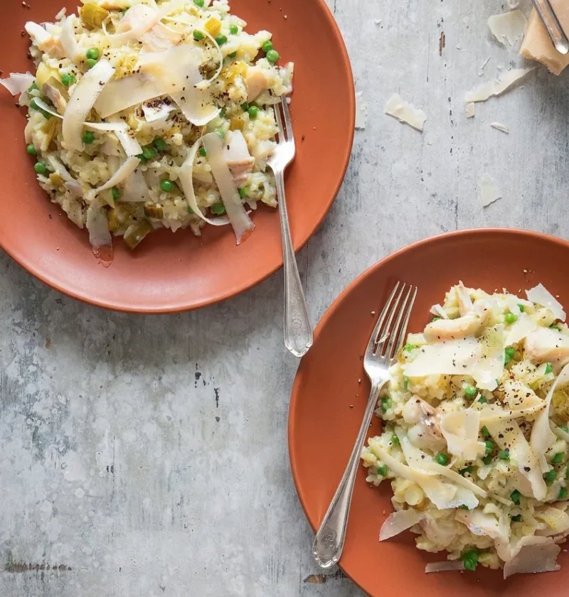 Hairy Bikers smoked haddock risotto on two terracotta plates with peas, leek and shaved Parmesan