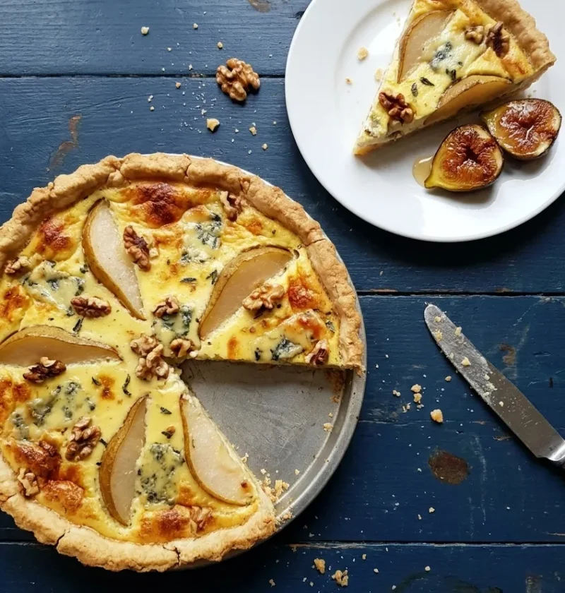 Homemade pear and Stilton tart with walnuts in a sage custard, one slice served with roasted figs and honey